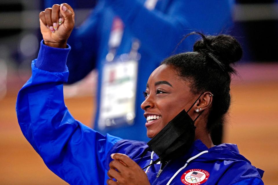 Simone Biles cheers during gymnastics competition at the Tokyo Olympics.