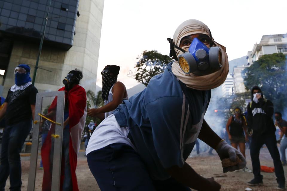 Anti-government protesters throw stones at the police during clashes at Altamira square in Caracas