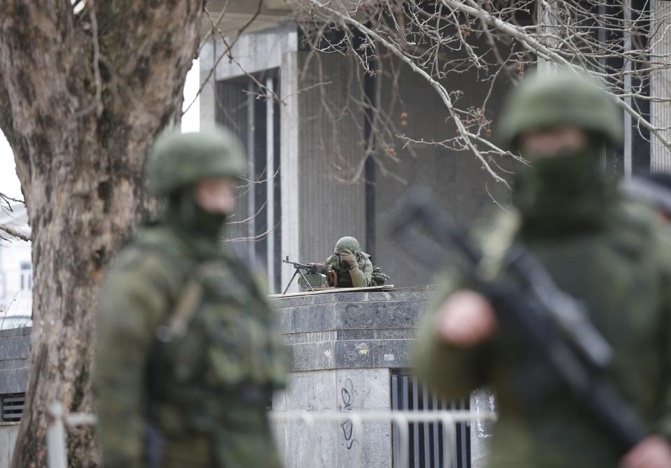 Armed men patrol around the regional parliament building in the Crimean city of Simferopol