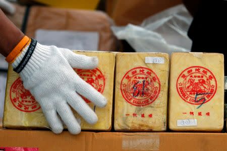 A Thai narcotics official arranges bags of heroin during the 47th Destruction of Confiscated Narcotics ceremony in Ayutthaya province, north of Bangkok, Thailand June 26, 2017. REUTERS/Chaiwat Subprasom