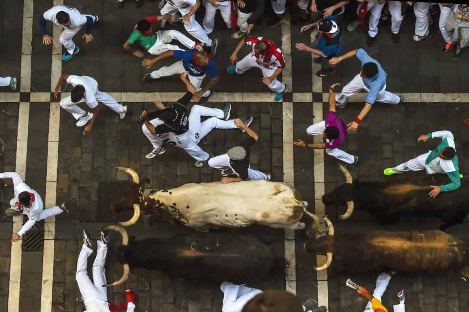 PAMPLONA, SPAIN - JULY 09:  Revellers run with the Victoriano del Rio Cortes' fighting bulls along Estafeta street during the fourth day of the San Fermin Running of the Bulls festival on July 9, 2015 in Pamplona, Spain. The annual Fiesta de San Fermin, made famous by the 1926 novel of US writer Ernest Hemmingway entitled 'The Sun Also Rises', involves the daily running of the bulls through the historic heart of Pamplona to the bull ring.  (Photo by David Ramos/Getty Images)