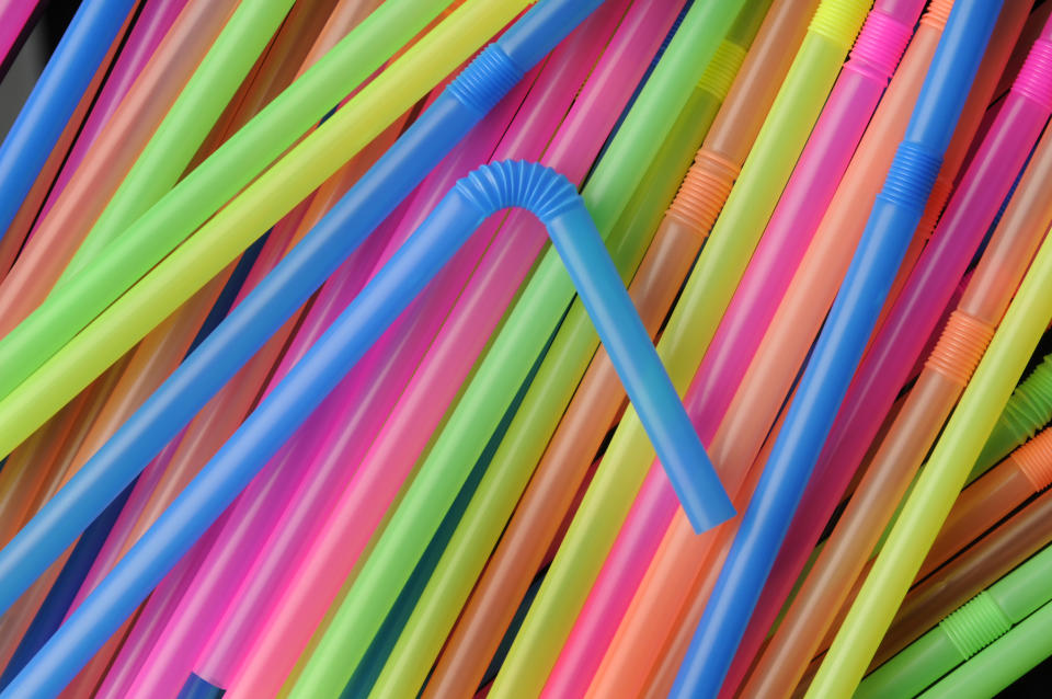 Many colourful single-use plastic straws.