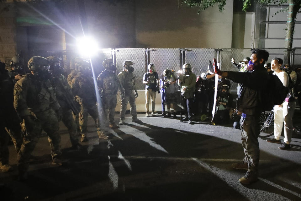 Federal agents keep demonstrators from advancing during a Black Lives Matter protest at the Mark O. Hatfield United States Courthouse Wednesday, July 29, 2020, in Portland, Ore. (AP Photo/Marcio Jose Sanchez)