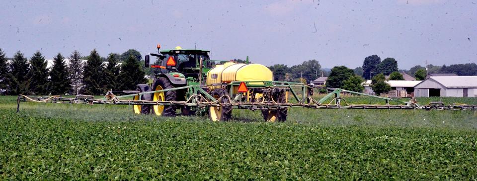 A farmer sprays a field of soy beans. Many fields throughout Ohio may have thick, leafy soybeans and knee-high corn, but a few had to be planted later and are still waiting for seeds to germinate and emerge.
