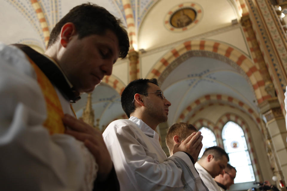 Members of the clergy pray during the ceremony of the unveiling of the statue of Pope John Paul II in the cathedral in Sarajevo, Bosnia, on Wednesday, April 30, 2014. Thousands of Bosnians have celebrated the canonization of Pope John Paul II by unveiling a statue in the heart of Sarajevo. John Paul’s support for Sarajevo's resistance to nationalist efforts to destroy the traditional inter-cultural and inter-religious fabric of the city during the 1992-95 war made him very popular among the city's predominantly Muslim population. The crowd shouted “long live the pope” as the three meter-high statue was unveiled Wednesday in front of the cathedral. (AP Photo/Amel Emric)