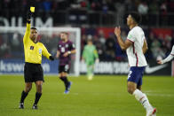 Referee Ivan Barton, left, gives a yellow card to United States' Miles Robinson, right, during the second half of a FIFA World Cup qualifying soccer match against Mexico, Friday, Nov. 12, 2021, in Cincinnati. The U.S. won 2-0. (AP Photo/Julio Cortez)