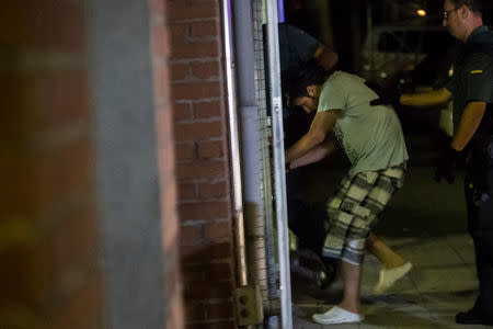 Spanish Civil Guards escort one of four men accused of involvement in an Islamist cell behind a van attack in Barcelona last week, in Tres Cantos, Spain, August 21, 2017. REUTERS/Juan Medina