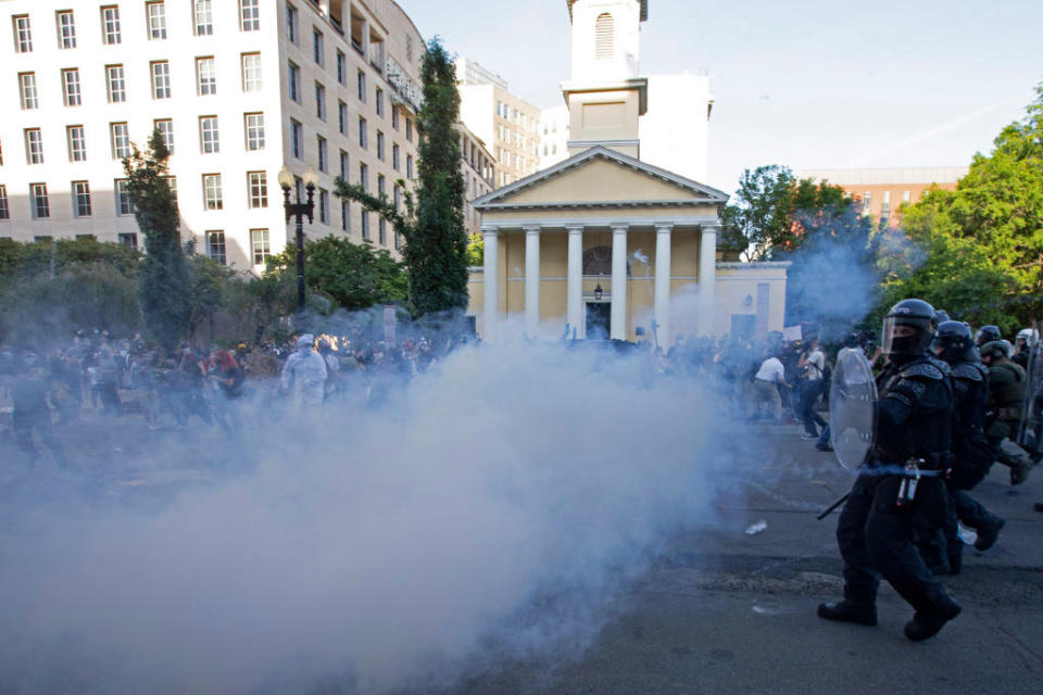 Police officers wearing riot gear push back demonstrators shooting tear gas next to St John's Episcopal Church on Monday. Source: Getty