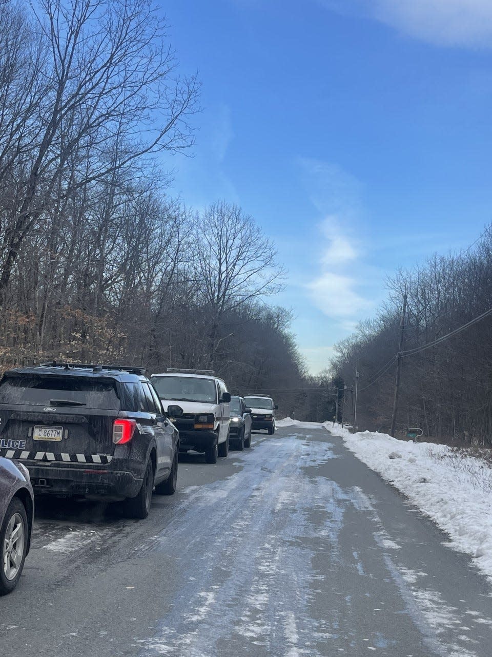 Vehicles from Pocono Mountain Regional Police and Pennsylvania State Police parked along a road in Long Pond on March 16, 2023.