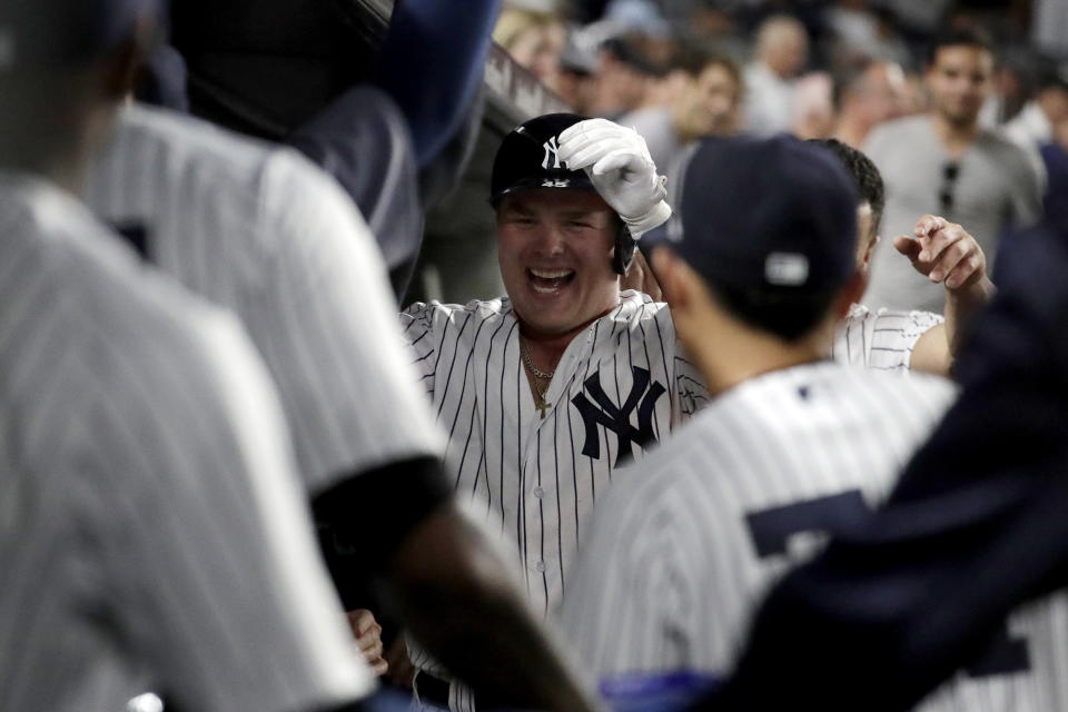 New York Yankees' Luke Voit, center, is congratulated in the dugout after hitting a solo home run off Boston Red Sox starting pitcher David Price during the fourth inning of a baseball game Wednesday, Sept. 19, 2018, in New York. (AP Photo/Julio Cortez)