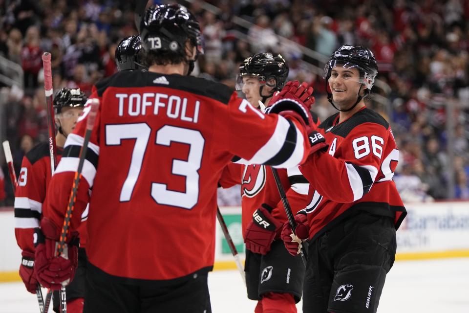 New Jersey Devils' Jack Hughes (86) smiles as he celebrates with Tyler Toffoli (73) after scoring a goal against the New York Rangers during the second period of an NHL preseason hockey game Wednesday, Oct. 4, 2023, in Newark, N.J. (AP Photo/Frank Franklin II)