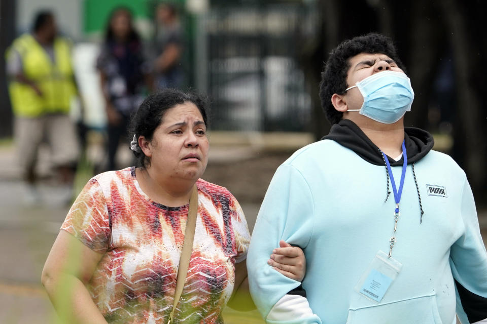 People walk along the road outside YES Prep Southwest Secondary school after a shooting on Friday, Oct. 1, 2021 in Houston. An employee at the Houston charter school was shot and wounded by a former student, police said. Houston Police Chief Troy Finner said a 25-year-old man surrendered after being surrounded by police. (AP Photo/David J. Phillip)