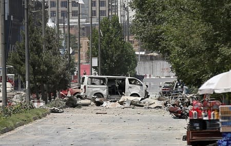 Damaged vehicles are seen at the the site of a blast in Kabul