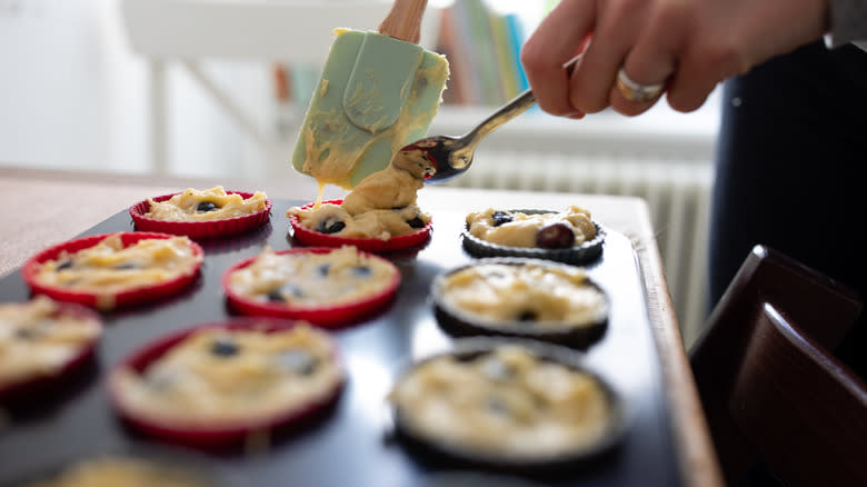 Adding muffin batter to pan