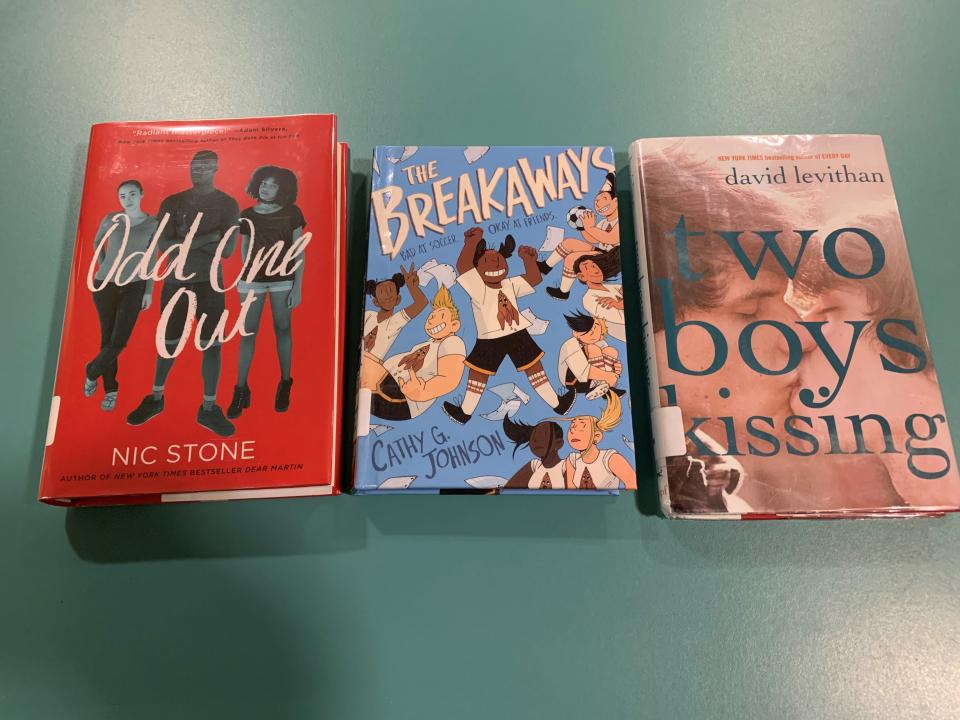 Three books among dozens on a growing 'watch list' of books in Indian River County schools provided by Moms for Liberty are pictured on a desk at the Indian River County Main Library Nov. 8, 2021.