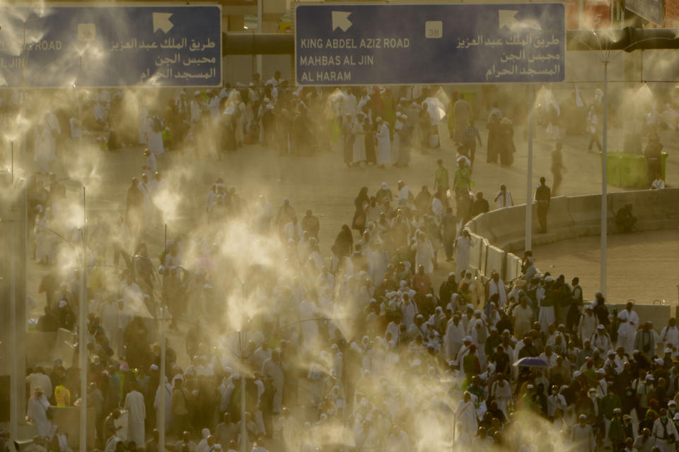 A water is sprayed on pilgrims to cool them as they walk to cast stones at a pillar in the symbolic stoning of the devil, the last rite of the annual Hajj pilgrimage, in Mina near the holly city of Mecca, Saudi Arabia, Wednesday, June 28, 2023. (AP Photo/Amr Nabil)