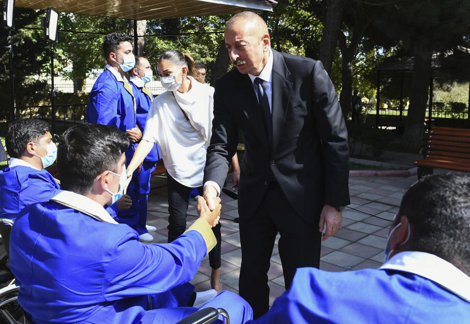 In this photo provided by the Azerbaijan's Presidential Press Office, Azerbaijani President Ilham Aliyev and his wife Mehriban Aliyeva visit the Central Military Clinical Hospital of the Defence Ministry to meet with Azeri service members, who were wounded during clashes over the separatist region of Nagorno-Karabakh in Baku, Azerbaijan, Wednesday, Sept. 30, 2020. Heavy fighting between Armenian and Azerbaijani forces over the separatist region of Nagorno-Karabakh has continued as statements from both sides indicating that the flare-up of a decades-old conflict that has killed dozens of people this week was no closer to an end. (Azerbaijani Presidential Press Office via AP)