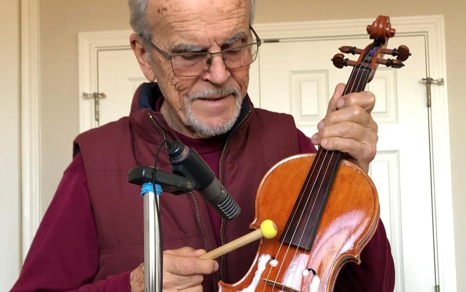 Prof Joseph Nagyvary, leading researcher into Stradivarius instruments, is seen here conducting a simple tonal experiment by knocking a violin's wooden body with a small mallet - Joseph Nagyvary/News Scan