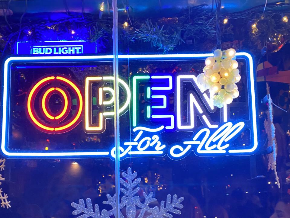 Photo showing a rainbow neon sign that says "Open For All."