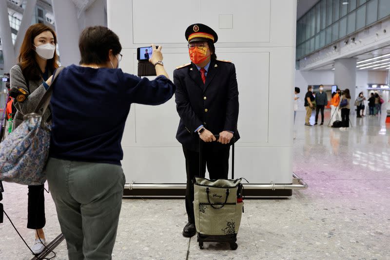 A passenger dressed as train driver poses for a picture at West Kowloon High-Speed Train Station Terminus on the first day of the resumption of rail service to mainland China, during the coronavirus disease (COVID-19) pandemic in Hong Kong