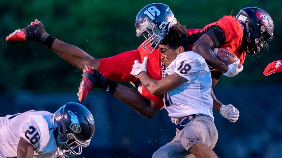 East Forsyth’s K.J. Wright (18) loses his helmet as he stops Rolesville’s Rory Jones (8) in the second quarter on Friday, August 26. 2022 at Roseville High School in Rolesville, N.C.