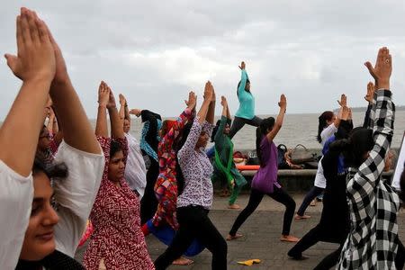 Participants practice yoga on International Yoga Day on a seafront promenade in Mumbai, June 21, 2017. REUTERS/Shailesh Andrade