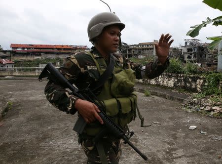 A government soldier gestures during as they clear the area with the local government members inside a war-torn in Marawi city, southern Philippines October 19, 2017. REUTERS/Romeo Ranoco
