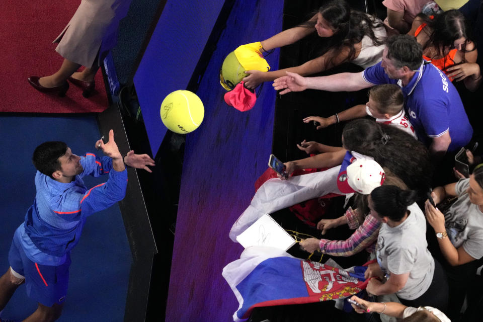 Novak Djokovic firma autógrafos tras vencer a Alex de Miñaur en los octavos de final del Abierto de Australia, el lunes 23 de enero de 2023, en Melbourne. (AP Foto/Dita Alangkara)