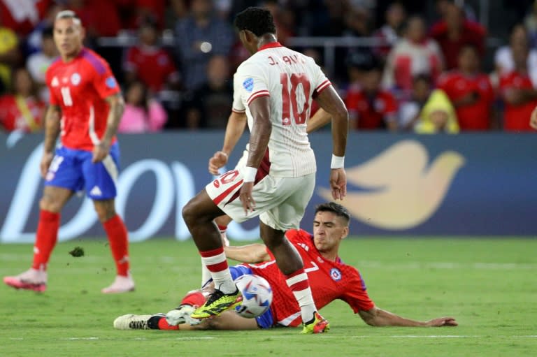 El delantero canadiense Jonathan David (20) disptua el balón con el chileno Marcelino Núñez (en el piso) en partido del Grupo A de la Copa América disputado el 29 de junio de 2024 en Orlando, Florida (Gregg NEWTON)