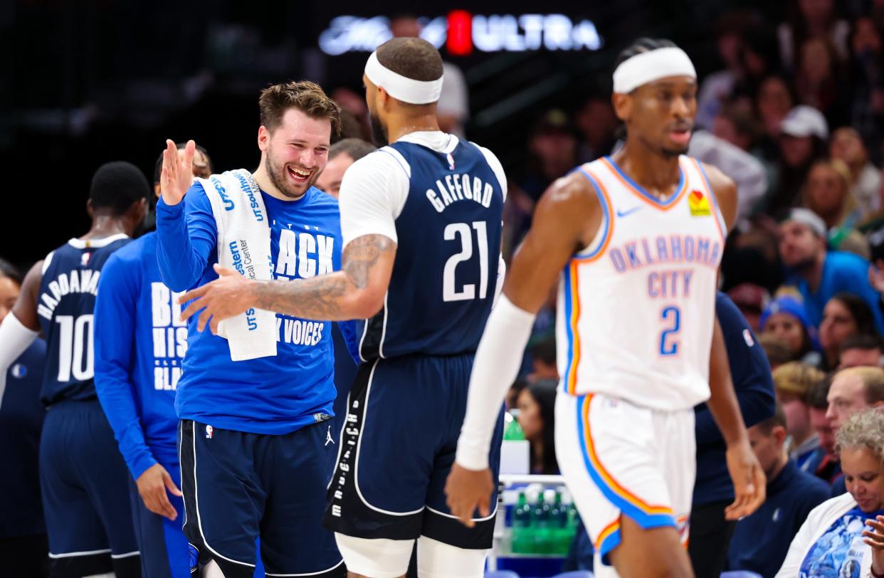 Feb 10, 2024; Dallas, Texas, USA; Dallas Mavericks guard Luka Doncic (77) celebrates with Dallas Mavericks center Daniel Gafford (21) behind Oklahoma City Thunder guard Shai Gilgeous-Alexander (2) during the second half at American Airlines Center. Mandatory Credit: Kevin Jairaj-USA TODAY Sports