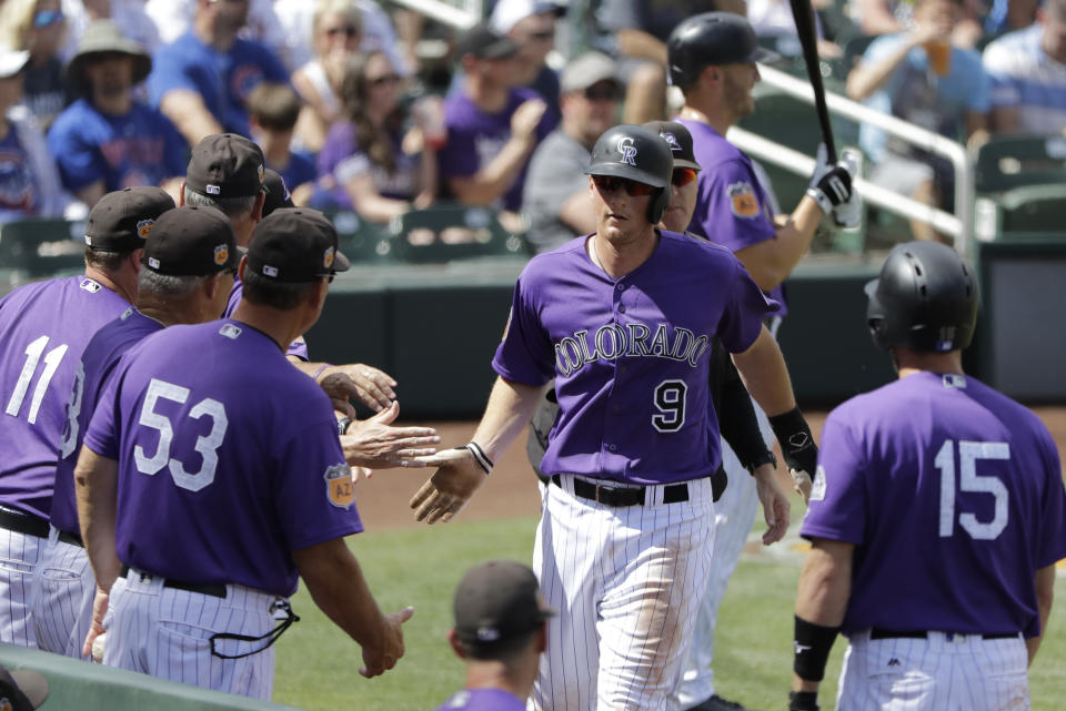 Colorado Rockies' DJ LeMahieu (9) is congraduated after scoring during the third inning of a spring training baseball game against the Chicago Cubs, Saturday, March 25, 2017, in Scottsdale, Ariz. (AP Photo/Darron Cummings)