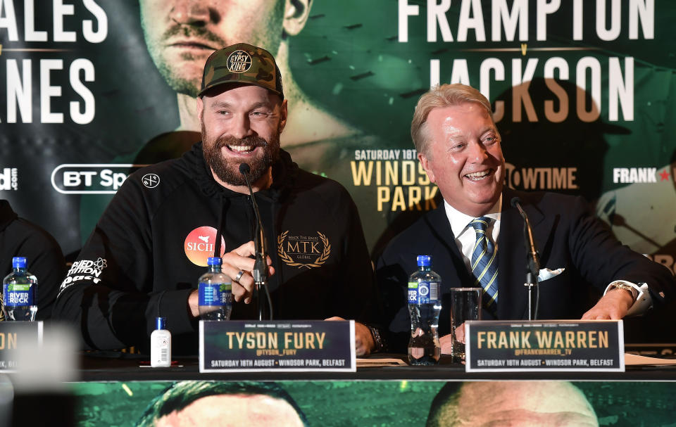 Legendary Hall of Fame promoter Frank Warren (R) shares a laugh with ex-heavyweight champion Tyson Fury on Aug. 14 at a news conference in Belfast, Northern Ireland. (Getty Images)