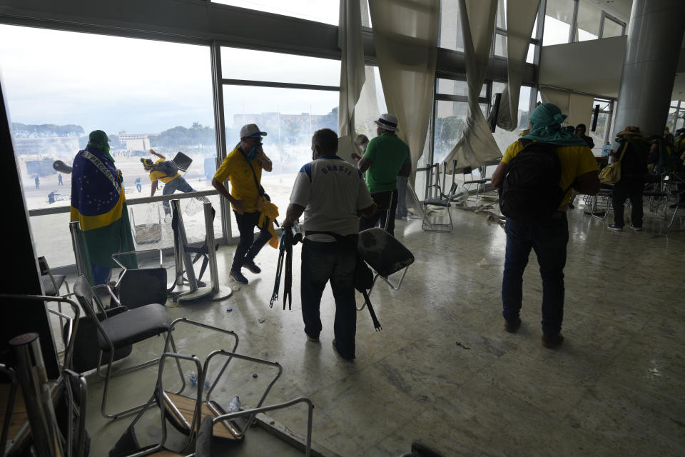 Protesters, supporters of Brazil's former President Jair Bolsonaro, clash with the police after they stormed the Planalto Palace in Brasilia, Brazil, Sunday, Jan. 8, 2023. Planalto is the official workplace of the president of Brazil. (AP Photo/Eraldo Peres)