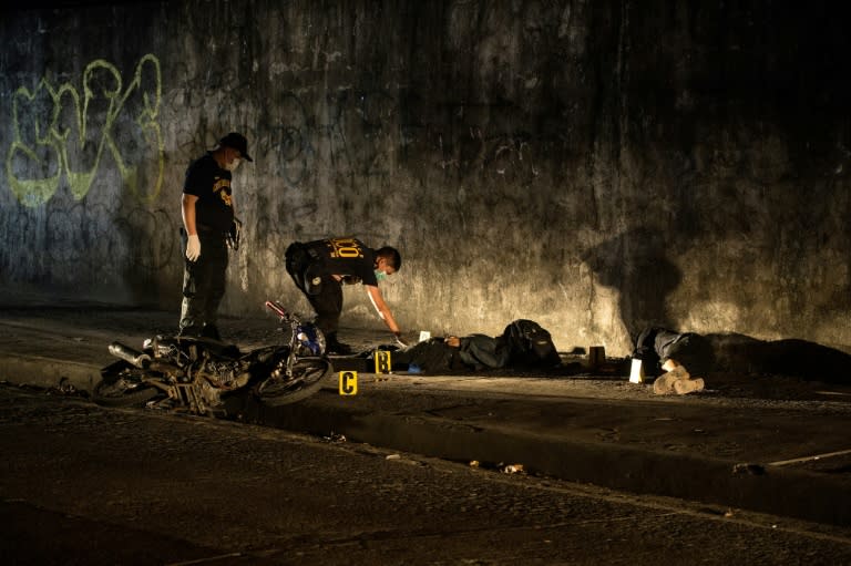 Officers investigate the killing of two alleged robbers in a gun fight with police in Manila