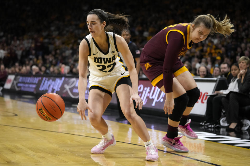 Iowa guard Caitlin Clark (22) runs down a loose ball in front of Minnesota center Sophie Hart, right, during the first half of an NCAA college basketball game, Saturday, Dec. 30, 2023, in Iowa City, Iowa. (AP Photo/Charlie Neibergall)