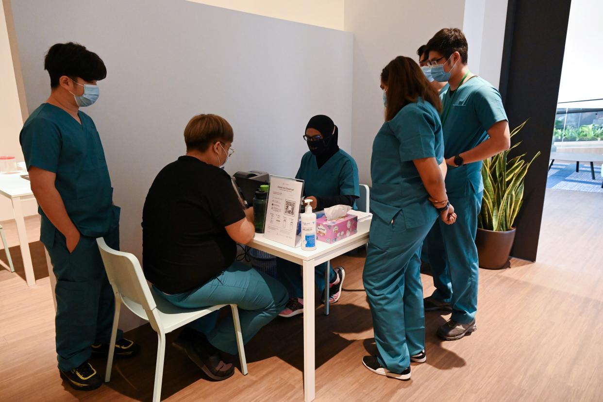 Health staffs prepare polymerase chain reaction test-kit for guests at the Connect@Changi. 