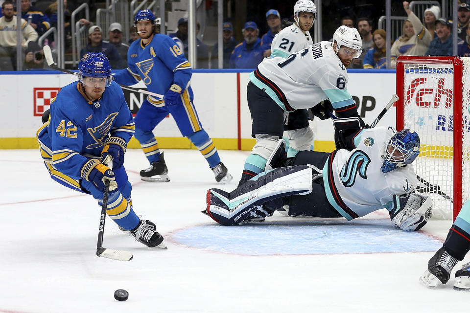 St. Louis Blues' Kasperi Kapanen (42) reaches for the puck that was deflected by Seattle Kraken goaltender Joey Daccord (35) during the second period of an NHL hockey game Saturday, Oct. 14, 2023, in St. Louis. (AP Photo/Scott Kane)