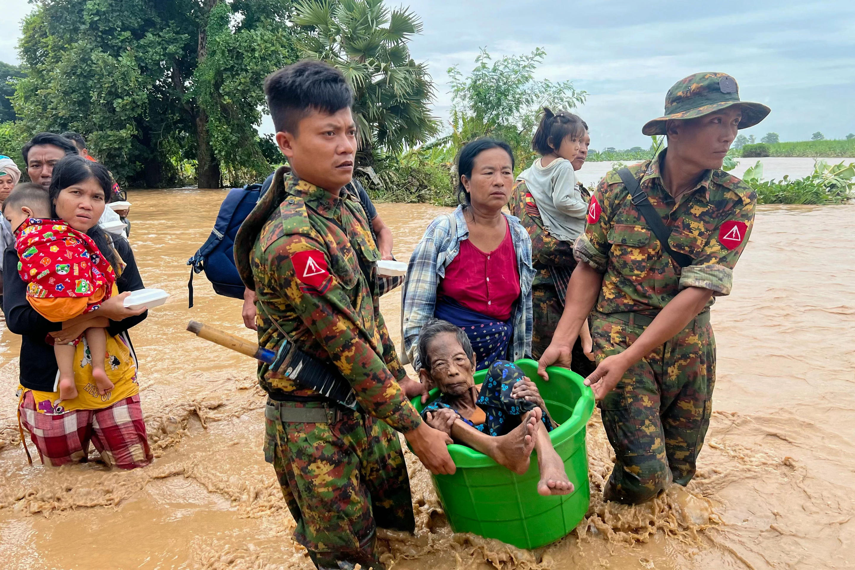 Residents are helped through flood waters by military personnel in Myanmar's Naypyidaw region on Friday following heavy rains in the aftermath of Typhoon Yagi.