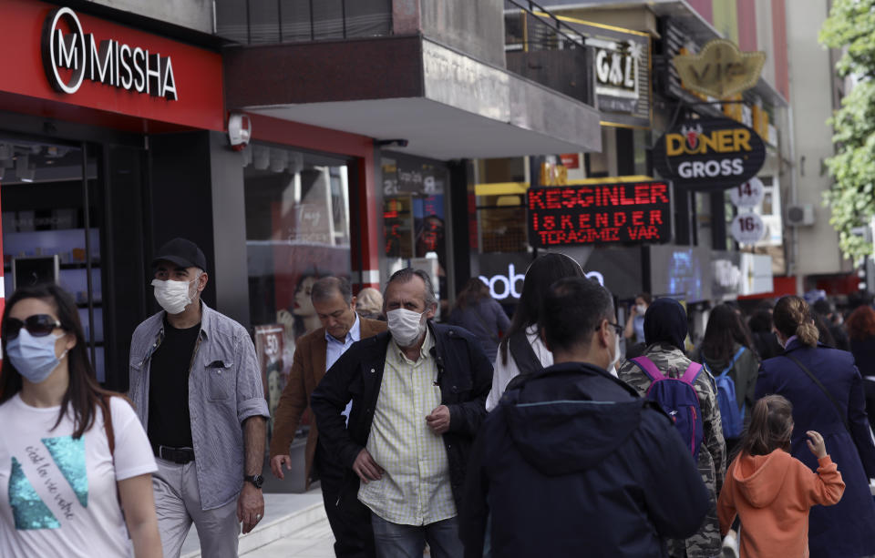 People walk along popular Tunali Hilmi Street, in Ankara, Turkey, Wednesday, June 3, 2020, days after the government lifted a series of restrictions imposed to fight the coronavirus pandemic. People crowded popular streets and parks while restaurants and cafes welcomed sit-in customers and beaches and museums reopened as part of Turkey's broadest easing of coronavirus restrictions. (AP Photo/Burhan Ozbilici)