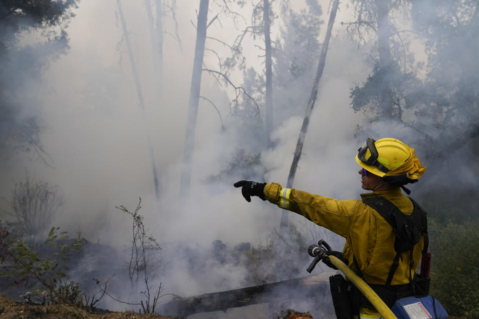 Firefighter Cody Nordstrom, of the North Central Fire station out of Kerman, Calif., monitors hot spots while fighting the CZU Lightning Complex Fire on Sunday, Aug. 23, 2020, in Bonny Doon, Calif. (AP Photo/Marcio Jose Sanchez)