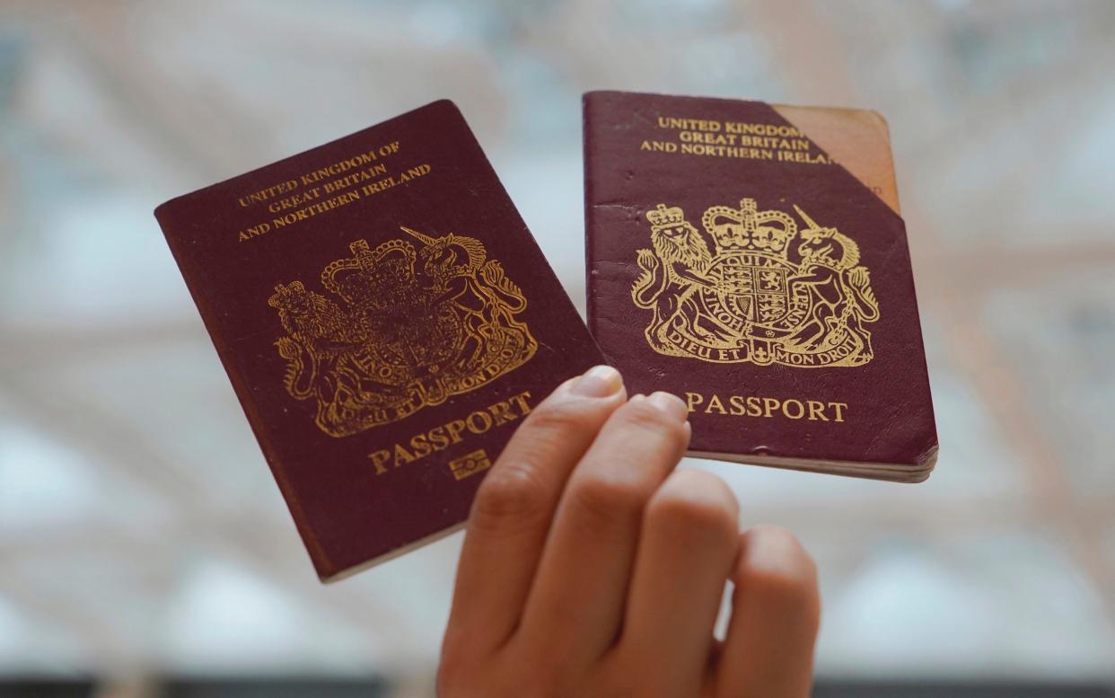 A protester holds up British National passports in a shopping mall during a protest against China's national security legislation - AP Photo/Vincent Yu