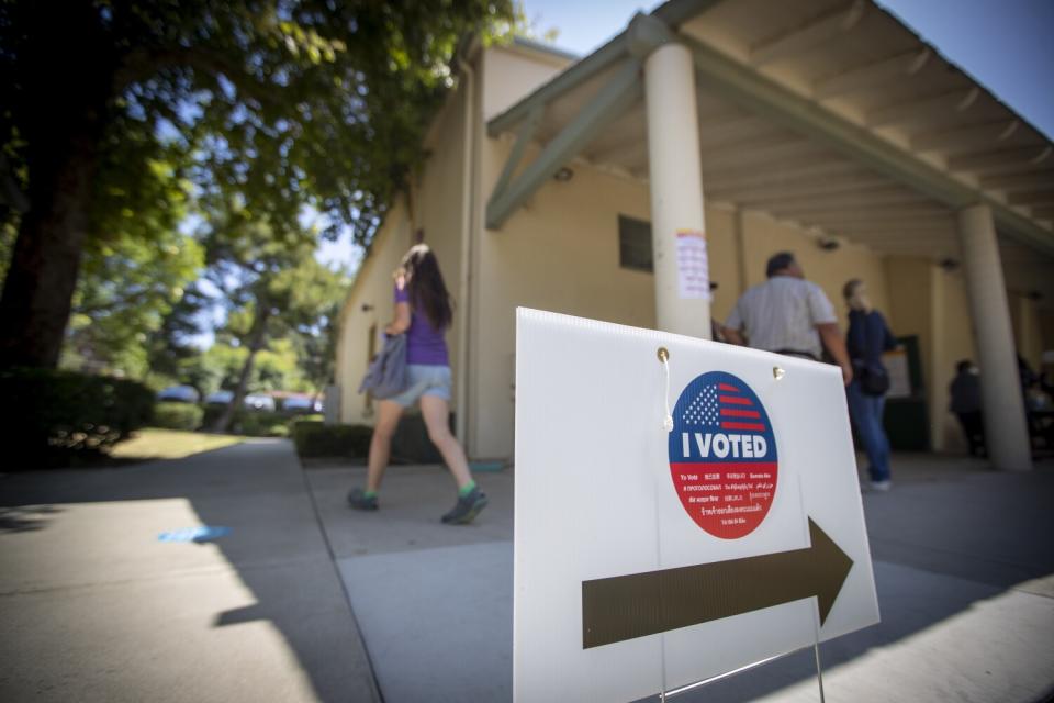 A sign with arrow pointing toward polling place