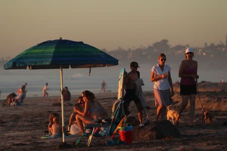 Families cool off at sunset in Solana Beach following a record setting day of temperatures according to local media, in Southern California, U.S., October 23, 2017. REUTERS/Mike Blake