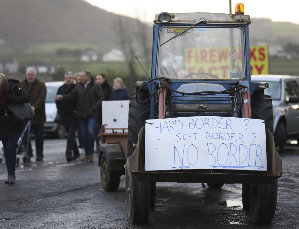 A banner hangs on a tractor during a demonstration on the Northern Ireland/Republic of Ireland border, near Newry in Northern Ireland, Saturday, Jan. 26, 2019. Protesters angered at the prospect of a hard Brexit built a mock wall across part of the Irish border, the theatrical gesture on Saturday was the centrepiece of a County Down demonstration against future border checks. (AP Photo/Peter Morrison)
