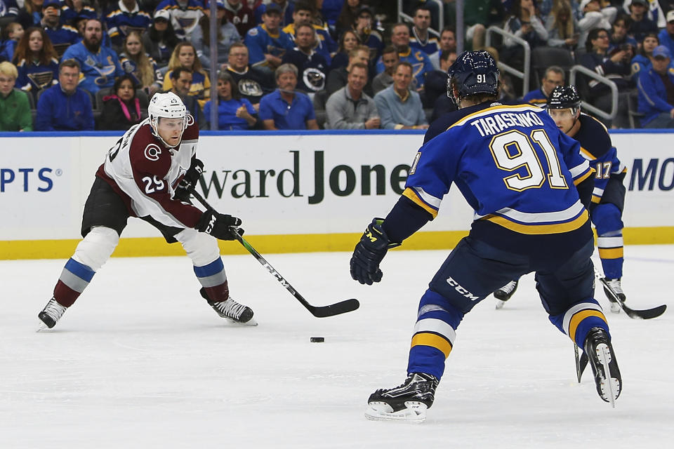 Colorado Avalanche's Nathan MacKinnon (29) handles the puck as St. Louis Blues' Vladimir Tarasenko (91), of Russia, and Jaden Schwartz (17) defend during the second period of an NHL hockey game Monday, Oct. 21, 2019, in St. Louis. (AP Photo/Scott Kane)