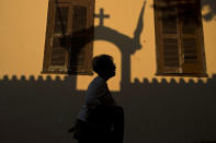 <p>A woman walks in the Plaka district of Athens, as the shadow of a church is seen on a building, on May 22, 2017. Lying under the shadow of the ancient Acropolis Hill, Plaka’s narrow streets and neoclassical architecture have for decades attracted tourists and Athenians alike. (Photo: Petros Giannakouris/AP) </p>