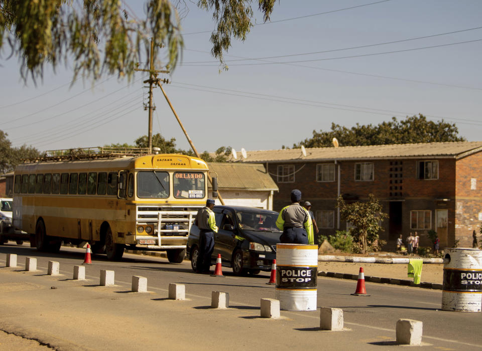 Police secure the area at a roadblock in Bulawayo, Zimbabwe, Monday, Aug. 19, 2019. Few people turned up Monday for an opposition protest in the Zimbabwe's second city as armed police maintained a heavy presence on the streets. (AP Photo/Mpofu)