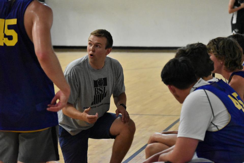 Mitchell boys' basketball coach Jackson Ryan speaks with his team during a break in its summer league game against Bloomfield.