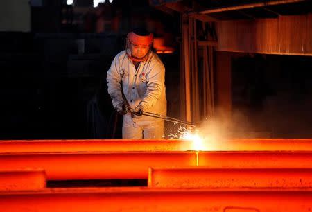 An employee works at the Huaxi Iron and Company in Huaxi village, China, December 2, 2010. REUTERS/Carlos Barria/File Photo
