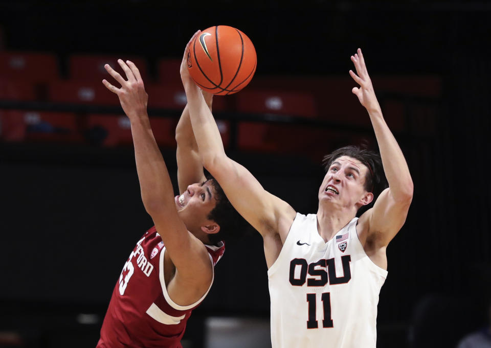 Stanford forward Brandon Angel (23) and Oregon State forward Dzmitry Ryuny (11) reach for a rebound during the first half of an NCAA college basketball game in Corvallis, Ore., Thursday, March 2, 2023. (AP Photo/Amanda Loman)